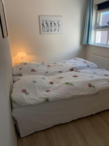 a bedroom with two beds with flowers on them at Friese Kust Villa in Workum