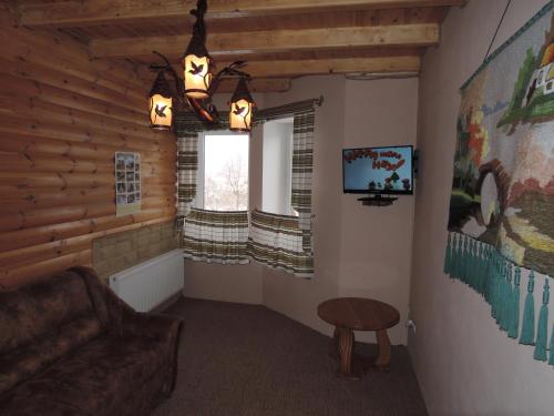 a living room with a couch and a window at АртГір гостинний двір in Mykulychyn