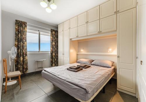 1 dormitorio con 1 cama, 1 silla y 1 ventana en Apartamento Cascabela, en Los Realejos