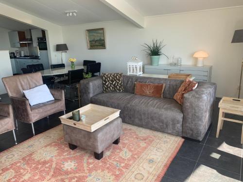 a living room with a couch and a table at Friese Kust Villa in Workum