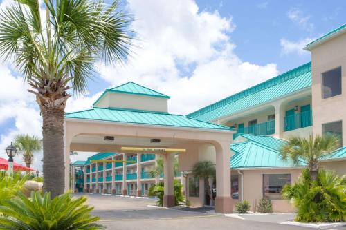 a palm tree in front of a building at Days Inn by Wyndham Gulfport in Gulfport
