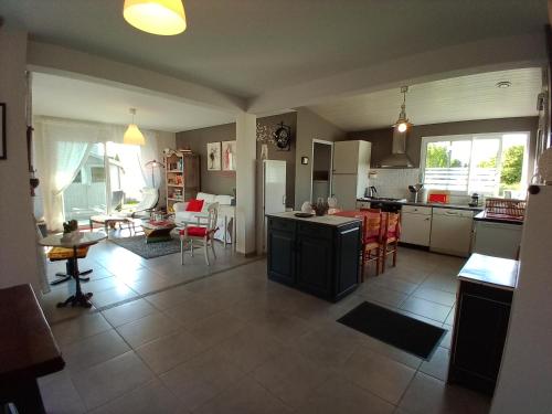 eine große Küche und ein Wohnzimmer mit einem Tisch in der Unterkunft Gite les bambous en BAIE DU MONT ST MICHEL in Dragey