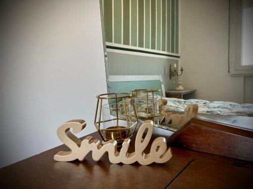 a sign that says smile sitting on a table next to a bed at Ravenna d'Amare in Marina di Ravenna
