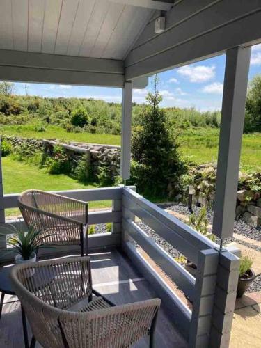 a porch with two chairs and a table at Rockschapel Cabin 30B in Annacloy