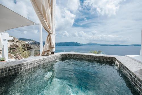 a swimming pool with a view of the water at Virginia's Cave Villas in Oia