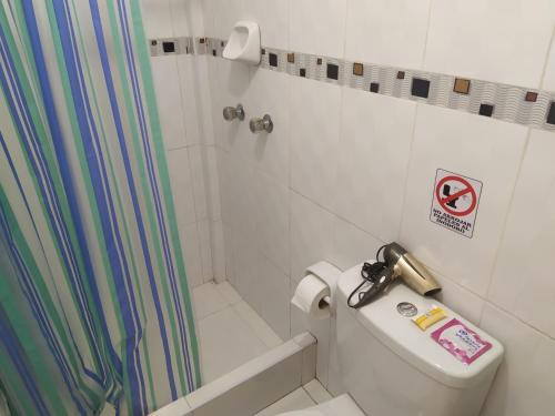 a bathroom with a shower curtain and a toilet at Ambigua Hospedaje in Trujillo