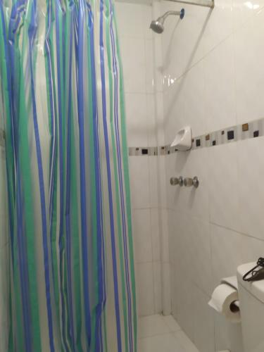 a bathroom with a shower curtain and a toilet at Ambigua Hospedaje in Trujillo