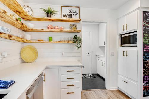 a kitchen with white cabinets and a black tile floor at Style & Shade in Horseshoe Bay