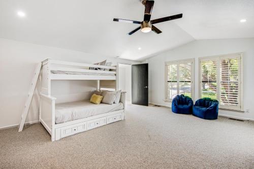 a white bedroom with a bunk bed and a ceiling fan at Style & Shade in Horseshoe Bay