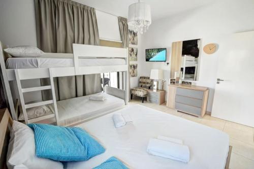 a room with three bunk beds and a desk at SunnyVillas: 4BR Villa☆Private Pool + Jacuzzi - Villa Amelie in Protaras