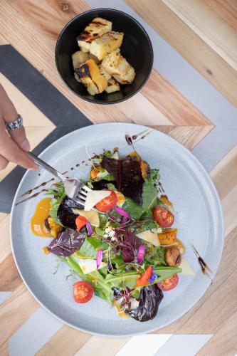 a plate of salad with a fork and a bowl of food at Casa Tunki in Cusco