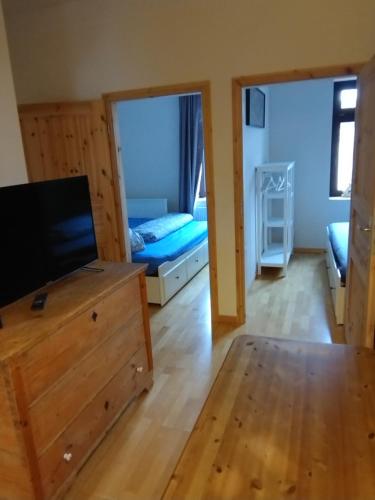 ライプツィヒにある2 Ferienwohnungen in einem Haus 2 km vom Zentrum Leipzigsのリビングルーム(ドレッサー内のテレビ付)、ベッドルーム1室が備わります。