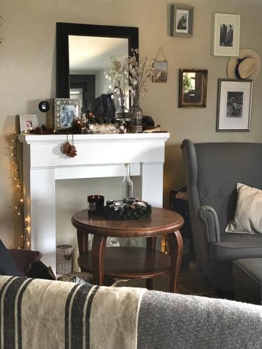 a living room with a fireplace and a table and a mirror at KisVulkán Nyúlontúl in Mencshely
