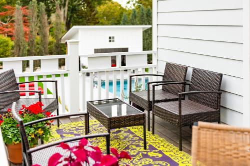 eine Terrasse mit Stühlen, einem Tisch und Blumen in der Unterkunft Seven - a boutique B&B on Shelter Island in Shelter Island