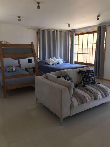 een woonkamer met een bank en een bed bij Cabaña de 1 ambiente para hasta 4 personas in Putaendo