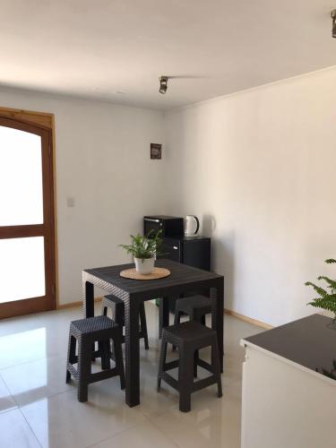 een tafel en stoelen in een kamer met een keuken bij Cabaña de 1 ambiente para hasta 4 personas in Putaendo