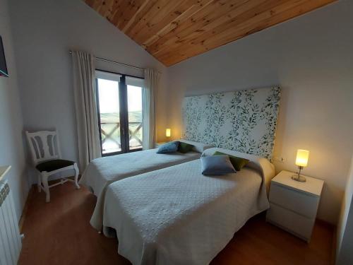 オヨス・デル・エスピーノにあるCasa Rural Alta Laderaのベッドルーム1室(ベッド2台、窓付)
