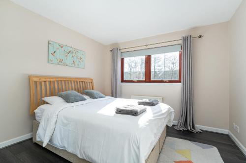 スターリングにあるOne Bedroom ground floor flatのベッドルーム(大きな白いベッド1台、窓付)