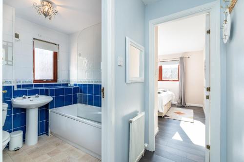 a bathroom with a tub sink and a toilet at One Bedroom ground floor flat in Stirling