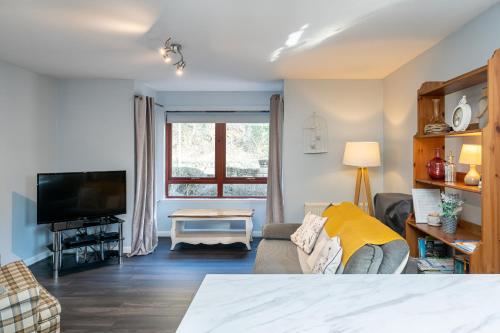 a living room with a couch and a tv at One Bedroom ground floor flat in Stirling