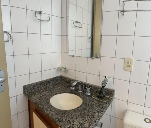 a bathroom with a sink and a mirror at Hotel Vila Rica Flat in Resende