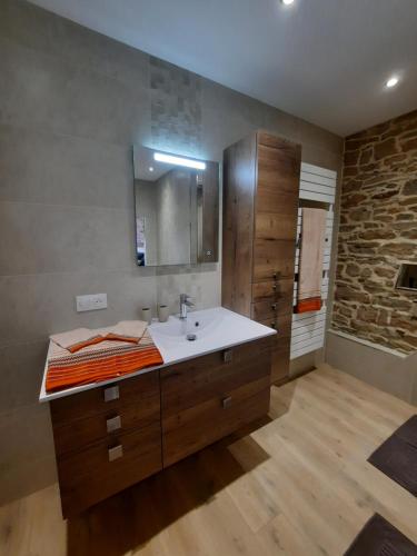 a bathroom with a sink and a stone wall at Les étangs du moulin d'Harcy in Lonny