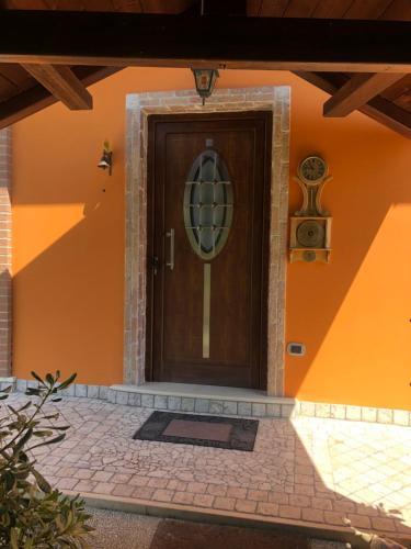 a wooden door on a house with an orange wall at Dependance con vista mare in Colonnella