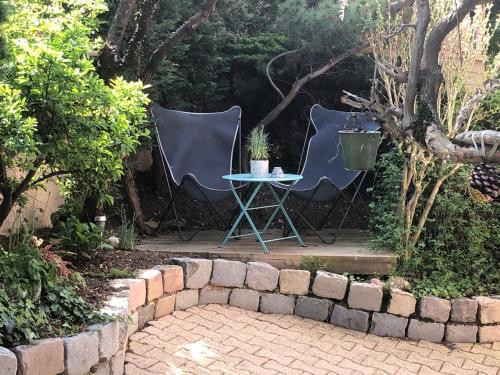 two chairs and a table in a garden at Le jardin de félicie in Trévoux