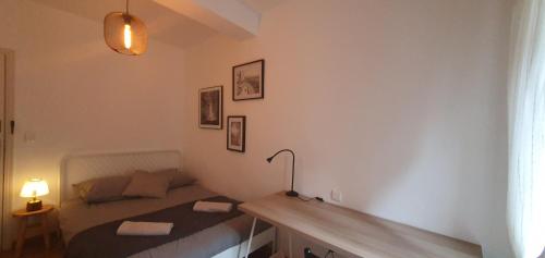 une petite chambre avec un lit et un bureau dans l'établissement SANTOCHA : appartement en plein coeur de ville !, à Carcassonne