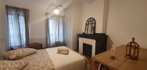 une chambre avec un lit, une table et une cheminée dans l'établissement SANTOCHA : appartement en plein coeur de ville !, à Carcassonne