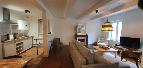 un salon avec un canapé et une table et une cuisine dans l'établissement SANTOCHA : appartement en plein coeur de ville !, à Carcassonne