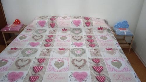 a bed with a blanket with hearts on it at Casa Elena II in Lerici
