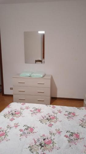 a bedroom with a bed and a dresser with a mirror at Casa Elena II in Lerici