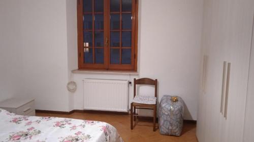 a bedroom with a bed and a chair and a window at Casa Elena II in Lerici