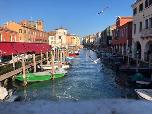 a canal with several boats in a city with buildings at Laguna Suite B&B in Chioggia