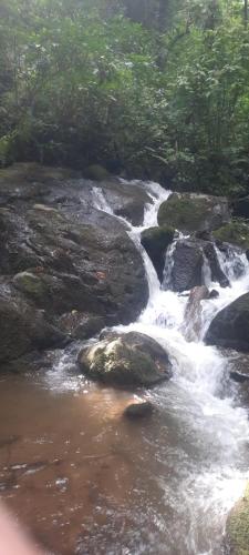 a stream of water rushing over rocks in a river at Chalé Lavanda com Hidro, Trilhas e Cachoeiras in São Francisco Xavier