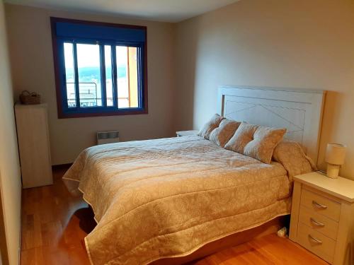 ein Schlafzimmer mit einem großen Bett und einem Fenster in der Unterkunft Apartamento Miramar in Pontevedra