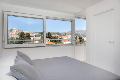 a white room with a table and two windows at Tennis apartment Dubrovnik, FREE parking, beach in Dubrovnik