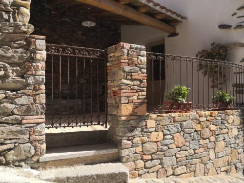 une maison en pierre avec une clôture et des escaliers dans l'établissement Domu Antiga, à Tertenìa