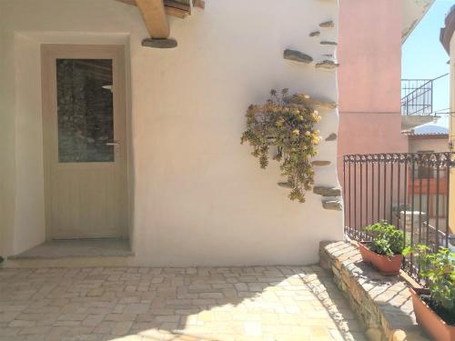 eine Eingangstür eines Hauses mit einem Kranz an der Wand in der Unterkunft Domu Antiga in Tertenìa