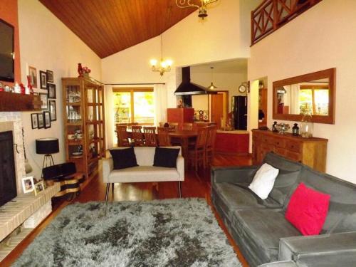 uma sala de estar com um sofá e uma mesa em Casa MARAVILHOSA com 4 Suítes em Condomínio em Camanducaia