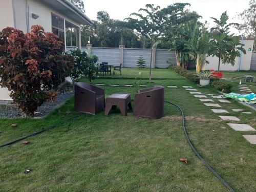 a yard with a table and a bench in the grass at Joleen Safari Park in Dar es Salaam