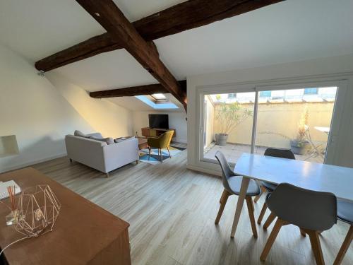un salon avec une table et des chaises dans l'établissement La Dolce Vita Nîmoise Terrasse 100 m des Arènes, à Nîmes