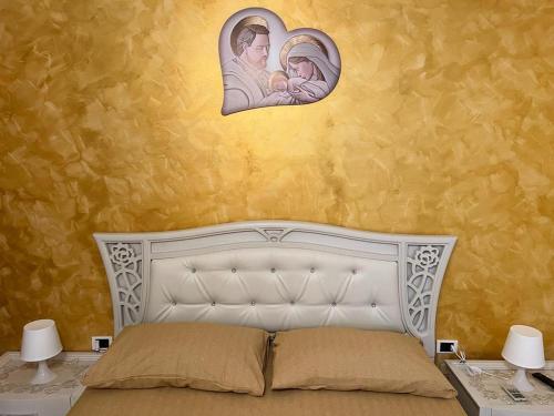 ein Schlafzimmer mit einem weißen Bett mit einem Bild eines Babys in der Unterkunft IL RIFUGIO DEL RE in Pisticci