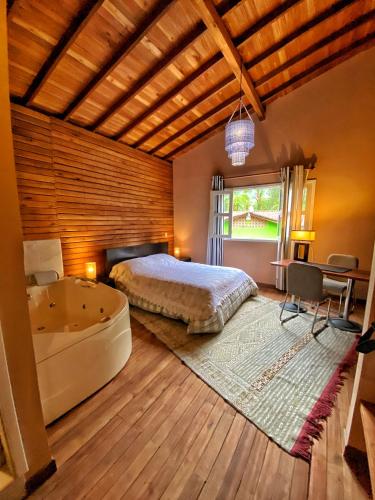 a bedroom with a bed and a tub and a table at Finca Turística de Alojamiento Rural Avalon in Jardin