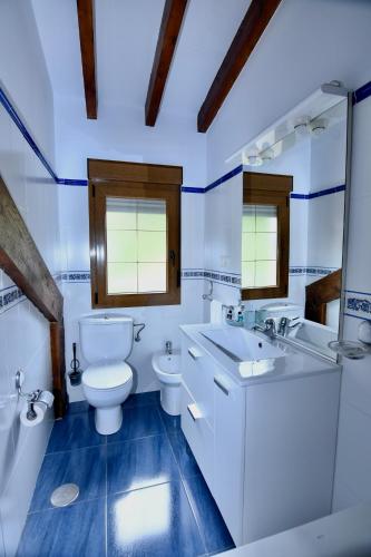 a white bathroom with a toilet and a sink at Apartamentos Rurales Valverde in Potes