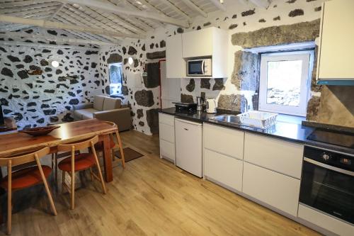 une cuisine avec une table et une salle à manger dans l'établissement Adega Baía Azul - The essence of Pico, à São Roque do Pico