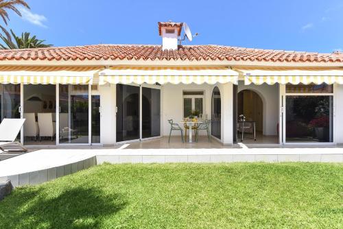 ein Haus mit einer Terrasse und einem Tisch im Hof in der Unterkunft Bungalow Sun Club EM259A by VillaGranCanaria in Playa del Ingles