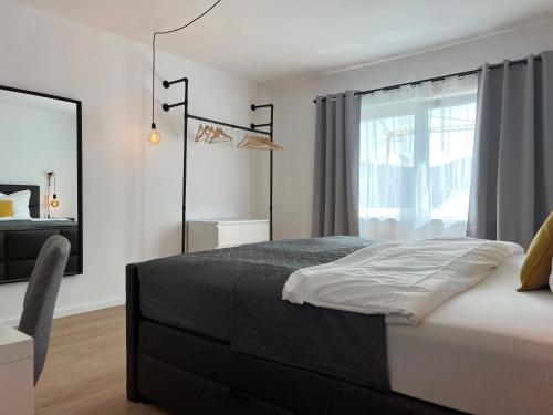 ein Schlafzimmer mit einem Bett und einem großen Fenster in der Unterkunft VonMos Balkon Apartment in Bernkastel-Kues