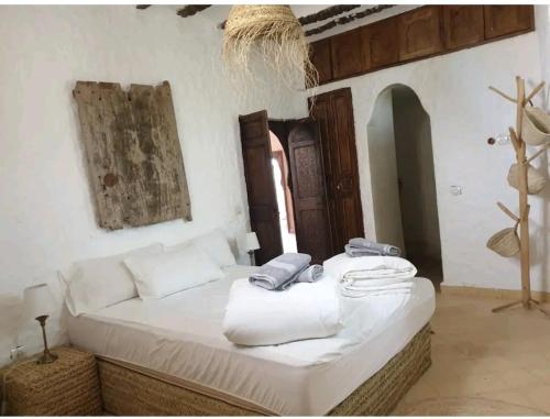 a bedroom with a white bed with towels on it at RIAD - Jnan Bnati - Pool in Marrakesh